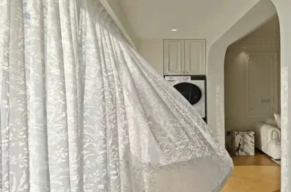 A long white Jacquard sheer curtain with a subtle leaf pattern.