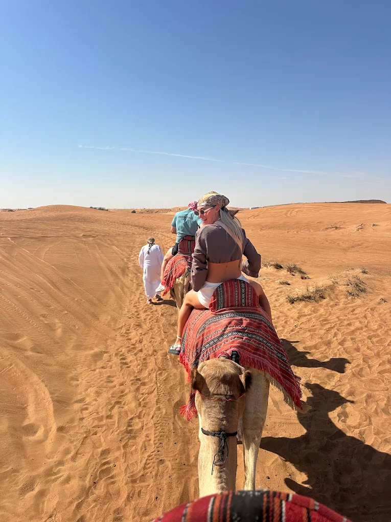 A Women Riding Camel In Dubai With Ibn Sahra Travels- desert safari