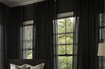 Dark moody bedroom featuring deep gray walls and long blackout curtains in black linen